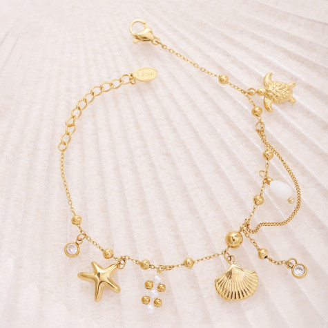 Bracelet doré avec perles et breloques plage