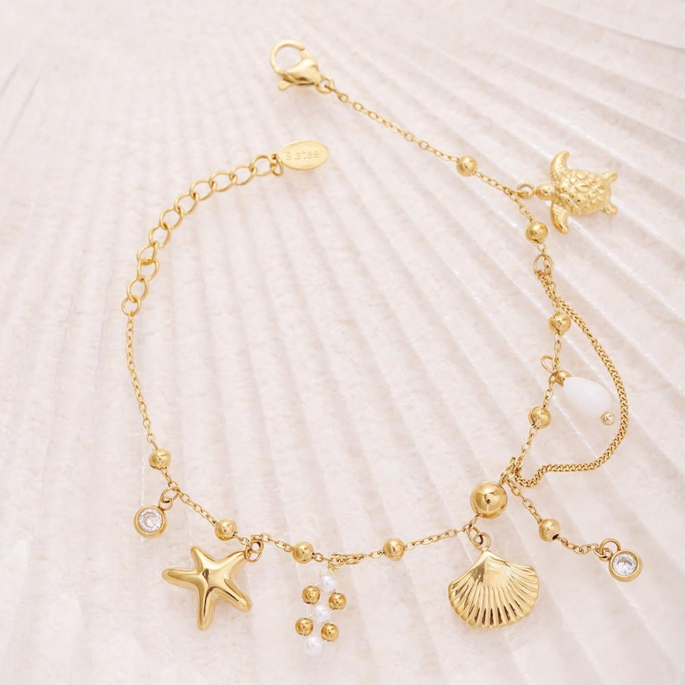 Bracelet doré avec perles et breloques plage